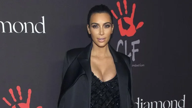 Η Kim Kardashian σε εκδήλωση με μαύρο σακάκι και φόντο το λογότυπο CLF Foundation.