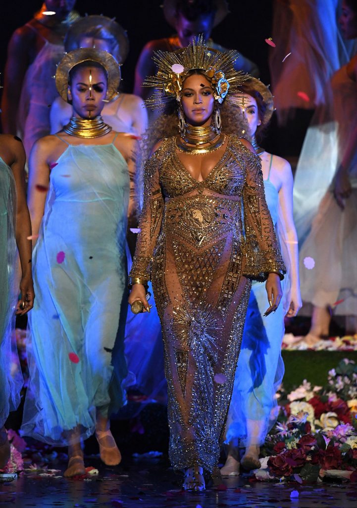 Η Beyoncé στη σκηνή των βραβείων Grammy με χρυσό φόρεμα και στέμμα.
