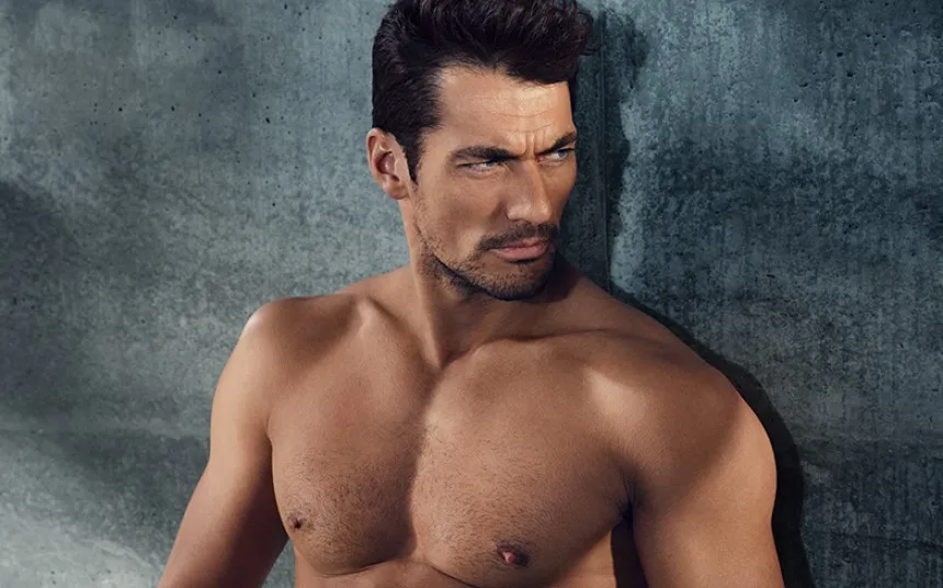 Ο David Gandy ποζάρει ημίγυμνος μπροστά από έναν τσιμεντένιο τοίχο.
