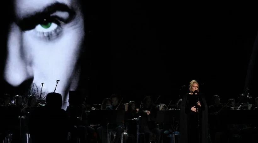 Η Adele τραγουδά στη σκηνή των Grammys με φόντο μια μεγάλη φωτογραφία του George Michael.