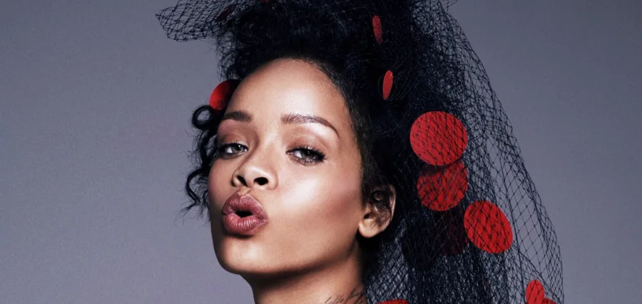 Κοντινό πορτρέτο της Rihanna με μαύρο δίχτυ στα μαλλιά και κόκκινες λεπτομέρειες.
