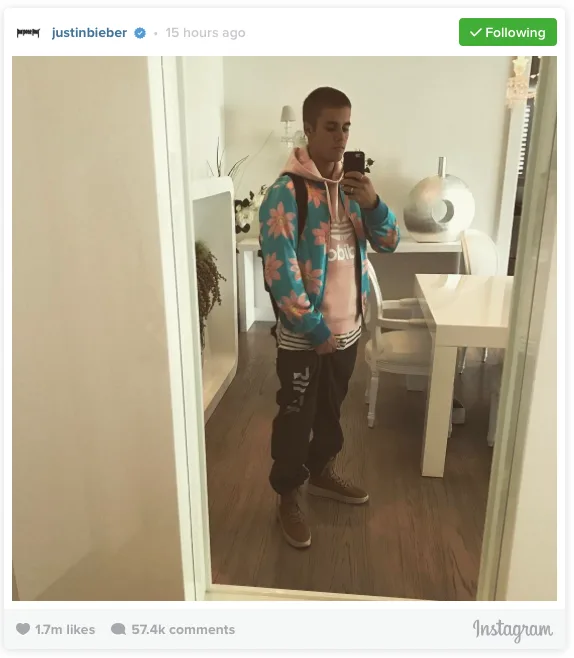 Ο Justin Bieber βγάζει selfie στον καθρέφτη φορώντας φλοράλ ζακέτα και ροζ φούτερ.