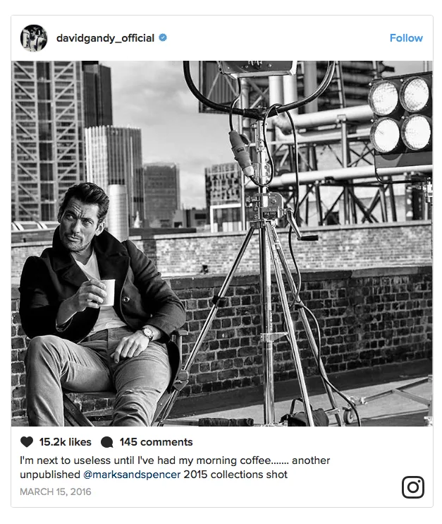 Ο David Gandy σε ασπρόμαυρη φωτογραφία από το Instagram, καθισμένος σε καρέκλα σκηνοθέτη κρατώντας έναν καφέ.