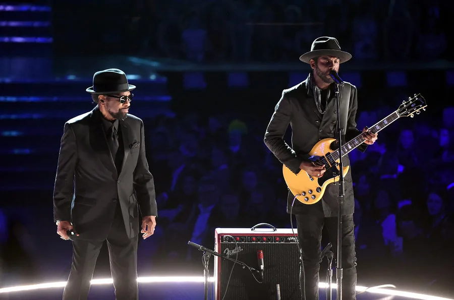 Δύο καλλιτέχνες στη σκηνή των βραβείων Grammys, ο ένας με κιθάρα.