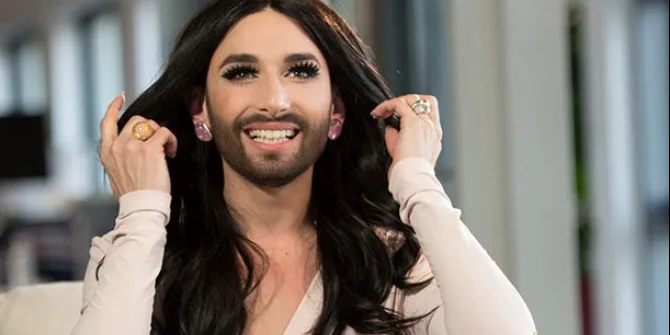 Η Conchita Wurst με μακριά μαύρα μαλλιά, μούσι και έντονο μακιγιάζ.