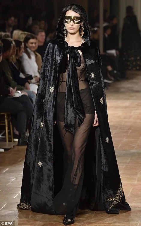 Η Bella Hadid στην πασαρέλα της Alberta Ferretti με μαύρη βελούδινη κάπα και διαφανές ένδυμα.