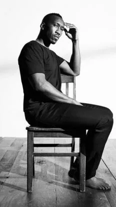 Ο Mahershala Ali ποζάρει καθισμένος σε καρέκλα για την καμπάνια της Calvin Klein.