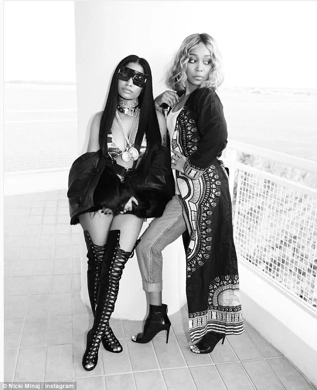 Η Nicki Minaj με μαύρα γυαλιά ηλίου και ψηλές μπότες δίπλα σε μια γυναίκα.
