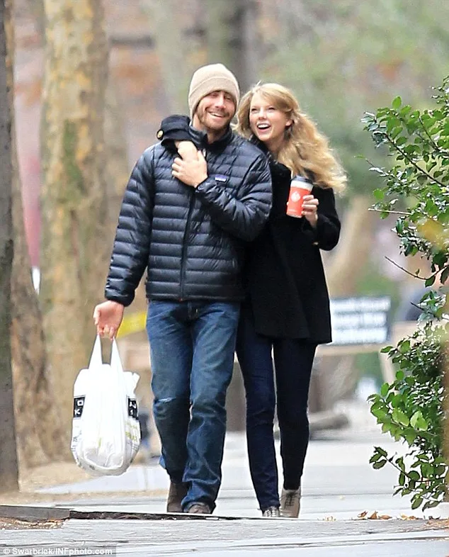 Η Taylor Swift και ο Jake Gyllenhaal περπατούν αγκαλιά στο δρόμο.