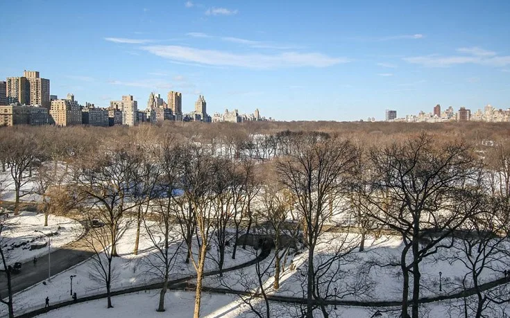 Θέα στο Central Park από ψηλά με χιονισμένα δέντρα και κτίρια του Μανχάταν στο βάθος.