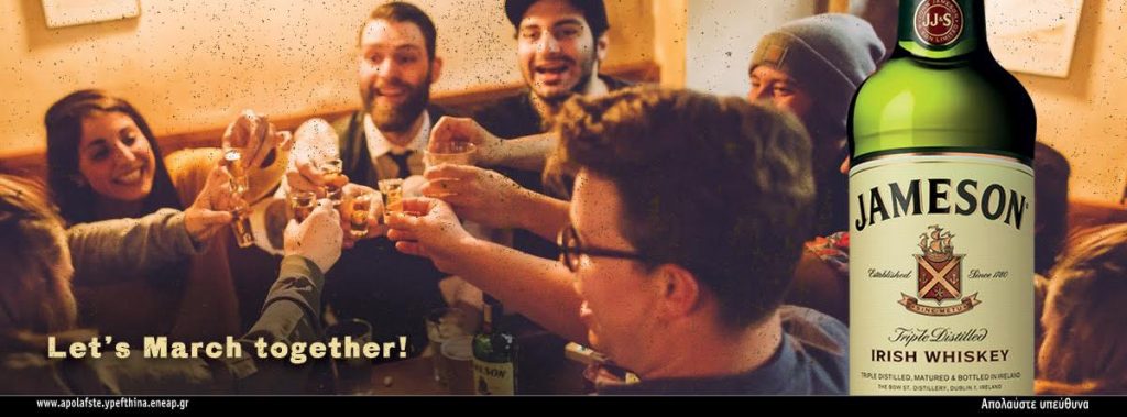 Παρέα φίλων τσουγκρίζει σφηνάκια Jameson Irish Whiskey σε μπαρ.