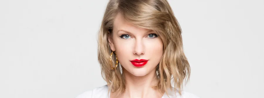 Κοντινό πορτρέτο της Taylor Swift με κόκκινο κραγιόν και ξανθά μαλλιά.