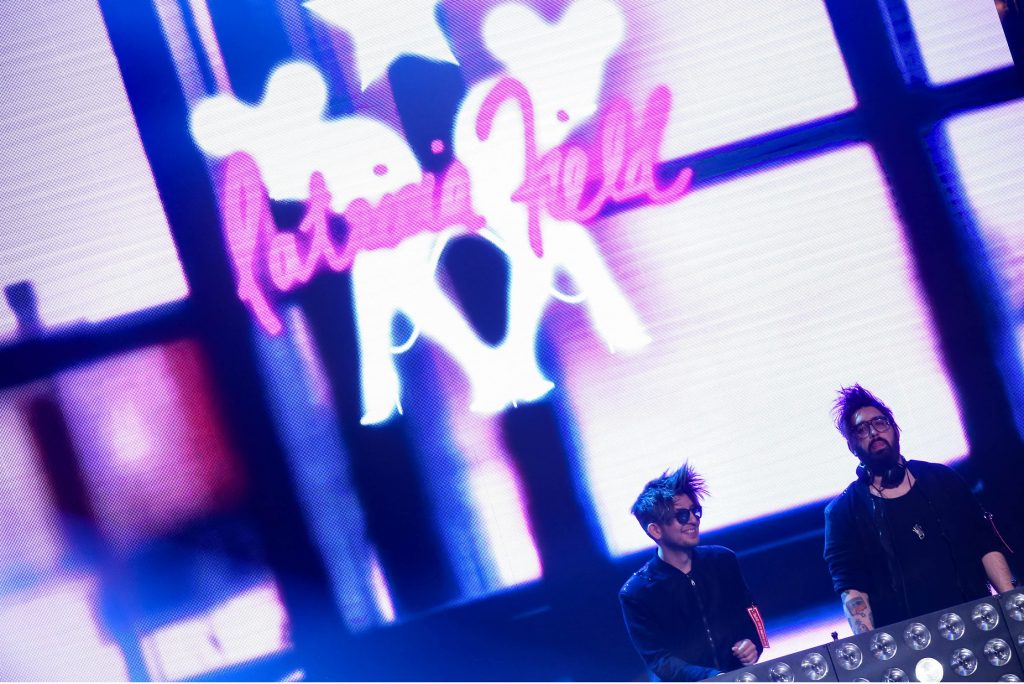Δύο DJs στη σκηνή του MadWalk 2017 μπροστά από οθόνη με το όνομα Patricia Field.