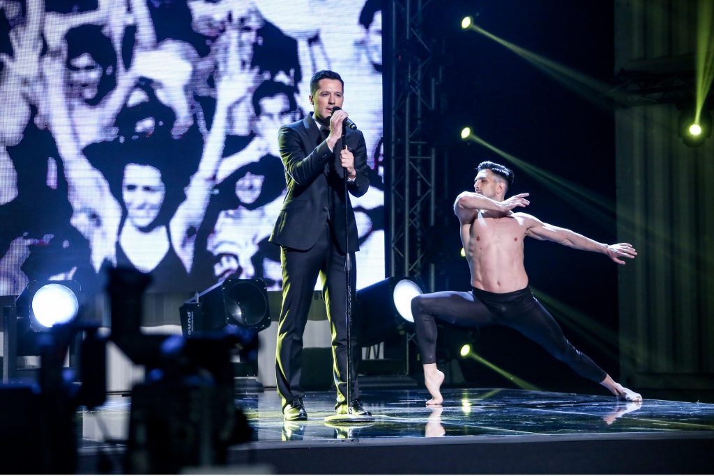 Καλλιτέχνης τραγουδά στη σκηνή του MadWalk 2017 δίπλα σε χορευτή.