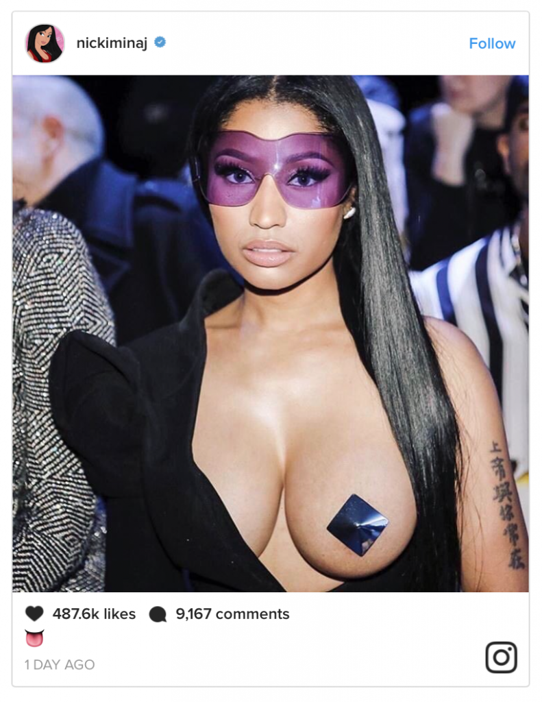 Η Nicki Minaj με αποκαλυπτικό μαύρο ρούχο, μωβ γυαλιά και κόσμημα στο στήθος στην Εβδομάδα Μόδας στο Παρίσι.