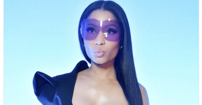 Η Nicki Minaj με μωβ γυαλιά ηλίου και μαύρο ρούχο.