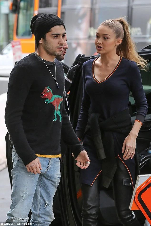 Η Gigi Hadid και ο Zayn Malik περπατούν δίπλα-δίπλα σε εξωτερικό χώρο.