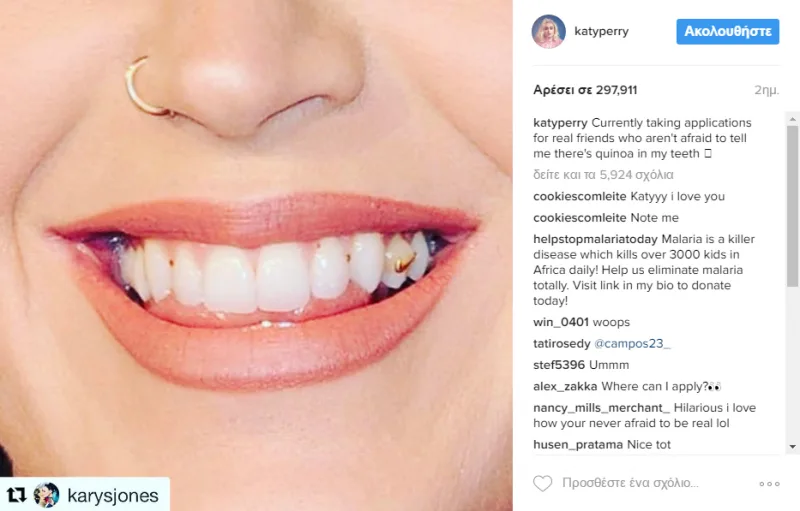Κοντινό πλάνο στο χαμόγελο της Katy Perry με υπολείμματα τροφής στα δόντια.