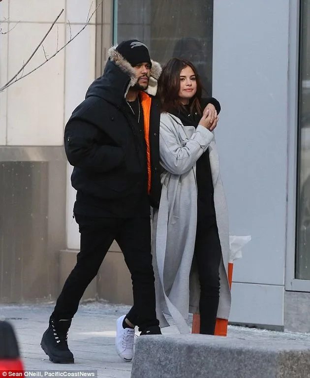 Ο Weeknd και η Selena Gomez περπατούν αγκαλιασμένοι στο δρόμο.