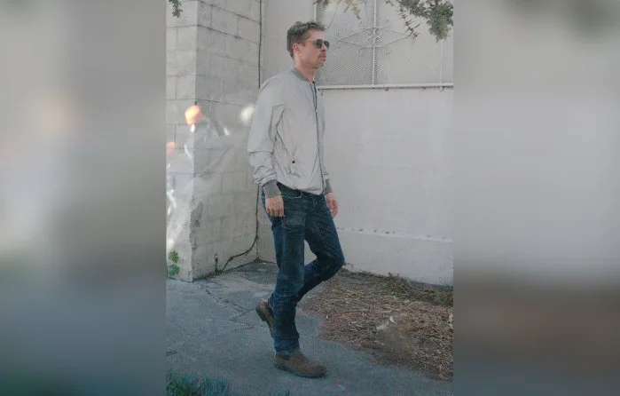 Ο Brad Pitt περπατάει στο δρόμο φορώντας γκρι τζάκετ και τζιν παντελόνι.