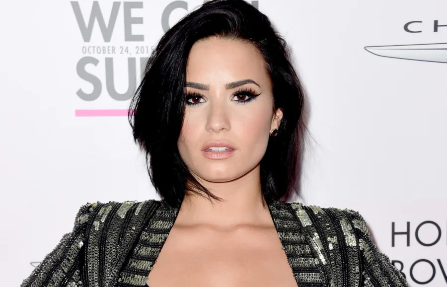 Η Demi Lovato σε επίσημη εμφάνιση με μαύρα μαλλιά και λαμπερό σακάκι.