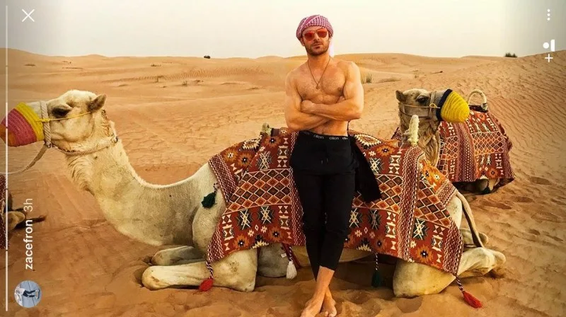 Ο Zac Efron ημίγυμνος στην έρημο δίπλα σε καμήλες.
