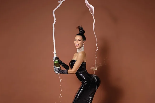 Η Kim Kardashian ποζάρει με μαύρο φόρεμα και σαμπάνια.