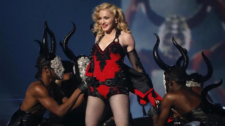Η Madonna στη σκηνή με χορευτές που φορούν μάσκες με κέρατα.