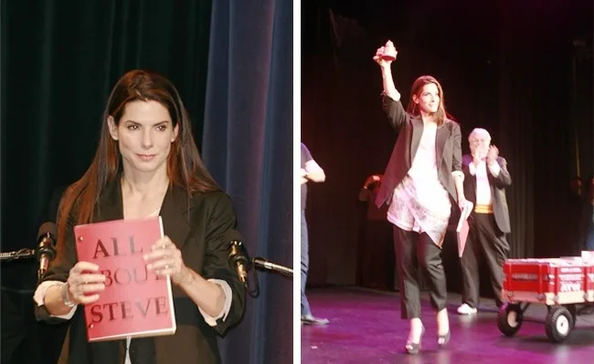 Η Sandra Bullock σε σκηνή κρατώντας ένα κόκκινο σενάριο και ένα βραβείο.
