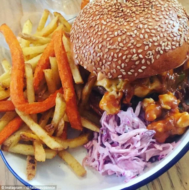 Ένα burger με σουσάμι, τηγανητές πατάτες και σαλάτα coleslaw σε πιάτο.