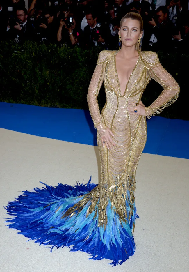 Η Blake Lively με χρυσό φόρεμα και μπλε φτερά στο Met Gala 2017.