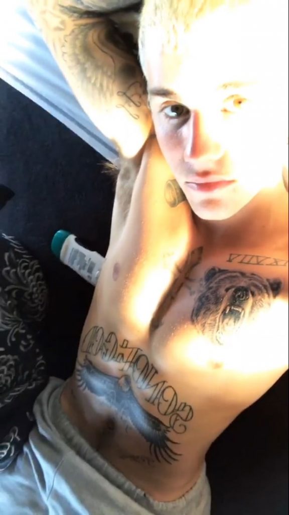 Ο Justin Bieber χωρίς μπλούζα δείχνει τα τατουάζ του στο στήθος και την κοιλιά.