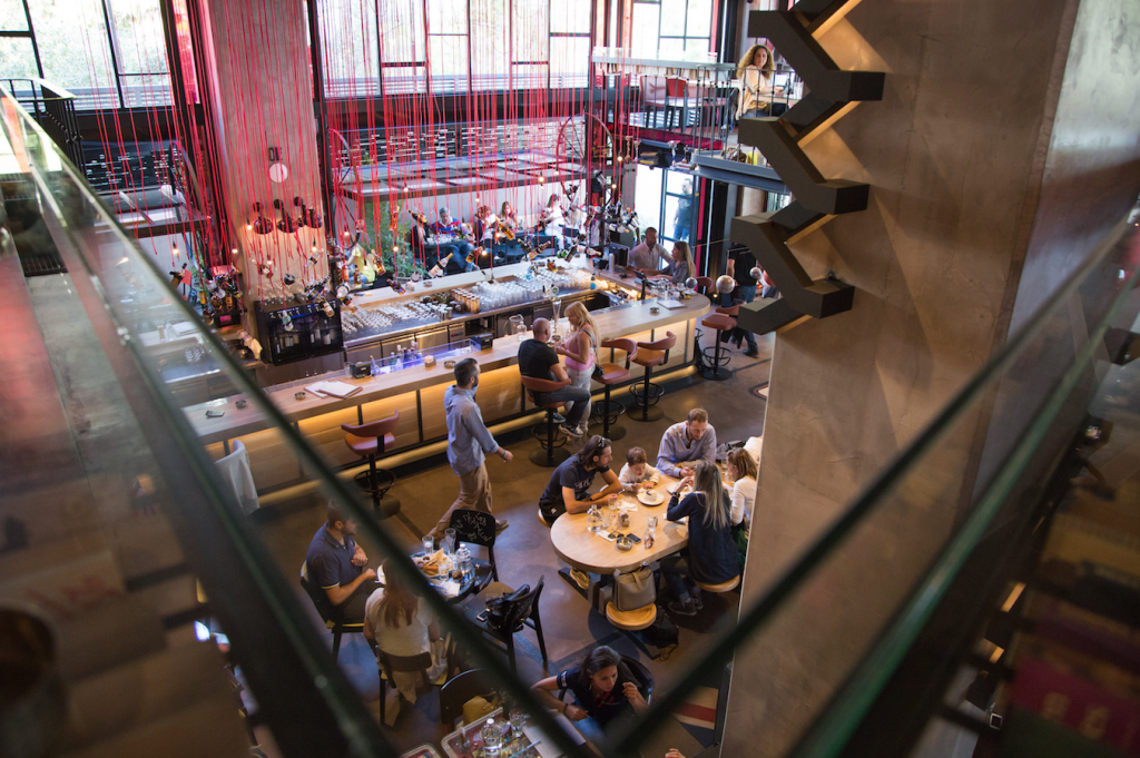 Εσωτερικό του all-day eatery Gazi College με κόσμο σε τραπέζια και μπάρα.
