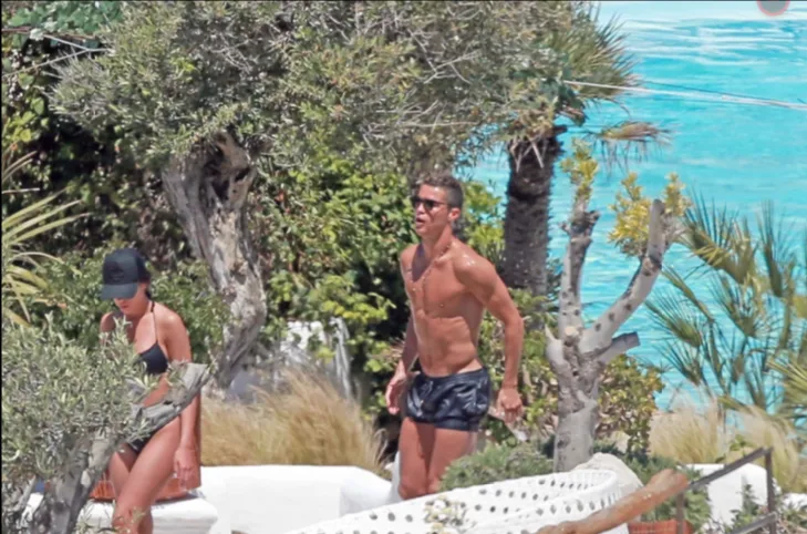 Ο Cristiano Ronaldo και η Georgina Rodriguez με μαγιό σε εξωτερικό χώρο με πισίνα.