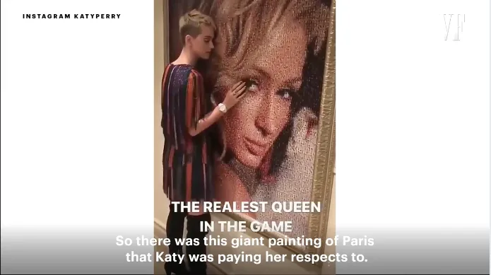 Η Katy Perry μπροστά από ένα μεγάλο πορτρέτο της Paris Hilton.