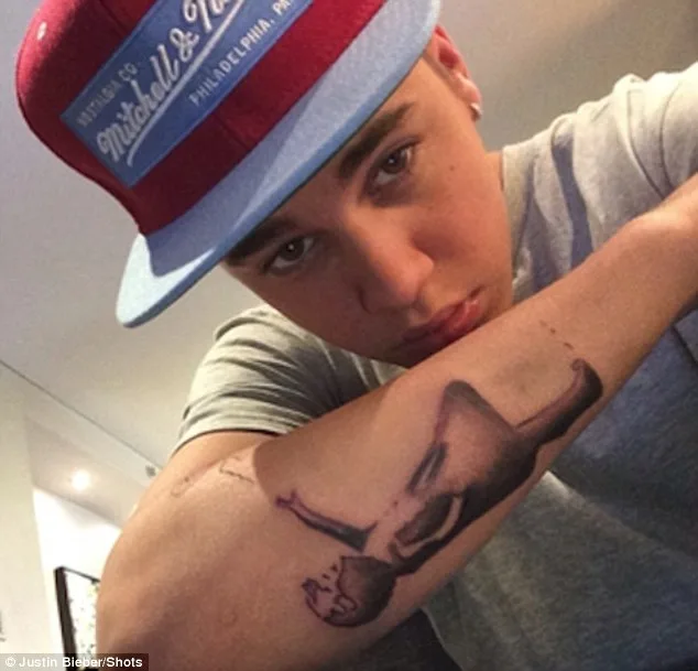 Ο Justin Bieber δείχνει ένα τατουάζ στο χέρι του.