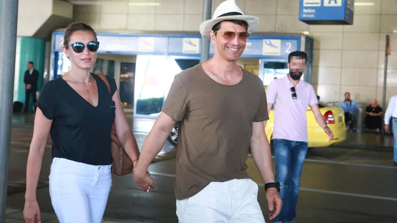 Ο Σάκης Ρουβάς και η Κάτια Ζυγούλη περπατούν πιασμένοι χέρι-χέρι σε εξωτερικό χώρο.
