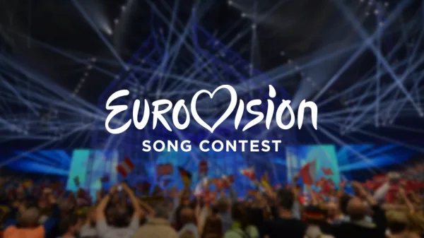 Το λογότυπο της Eurovision Song Contest πάνω από μια φωτισμένη σκηνή με πλήθος κόσμου.