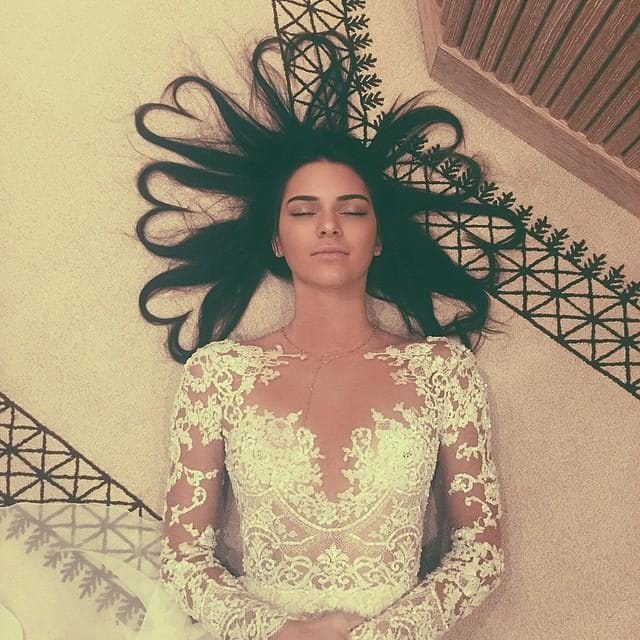 Η Kendall Jenner ξαπλωμένη στο πάτωμα με τα μαλλιά της σε σχήμα καρδιάς.