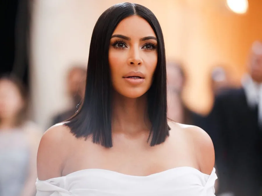 Η Kim Kardashian με μαύρο καρέ μαλλί και λευκό φόρεμα.