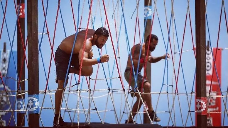 Δύο άνδρες παίκτες του Survivor αγωνίζονται σε στίβο μάχης με σχοινιά.