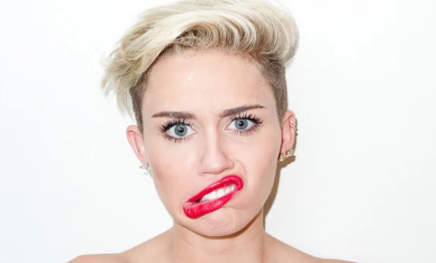 Η Miley Cyrus με ξανθό κοντό κούρεμα παίρνει μια αστεία γκριμάτσα.