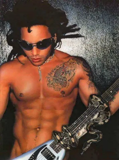 Ο Lenny Kravitz, ένας από τους celebrities με piercing στο στήθος, ποζάρει με γυαλιά ηλίου και κιθάρα.