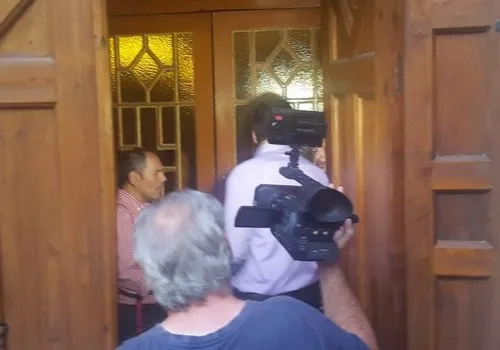 Άνθρωποι με κάμερα έξω από ξύλινη πόρτα ναού.