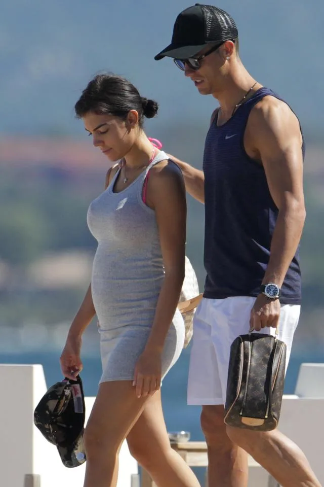 Ο Cristiano Ronaldo και η Georgina Rodriguez περπατούν σε εξωτερικό χώρο.