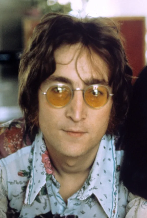 Ο John Lennon με στρογγυλά γυαλιά και εμπριμέ πουκάμισο.