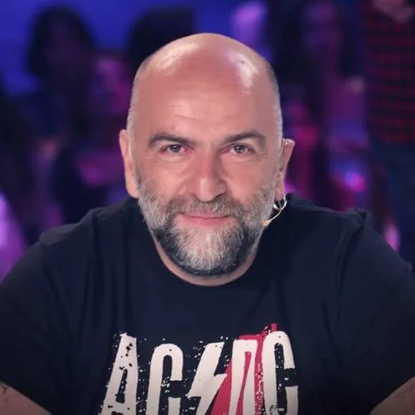 Καλλιτέχνης με μαύρο t-shirt AC/DC και μούσια.