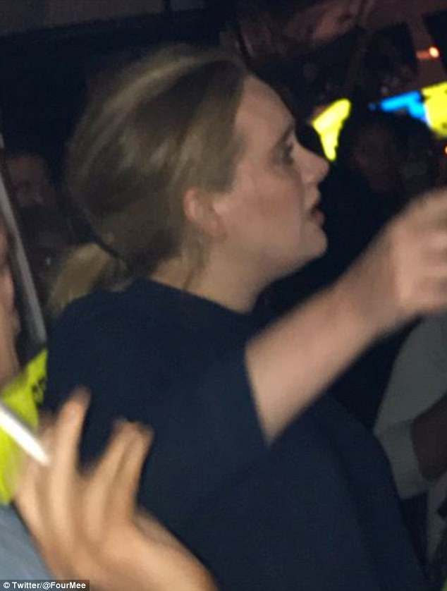 Η Adele σε νυχτερινή λήψη με σκούρο ρούχο και πιασμένα μαλλιά.