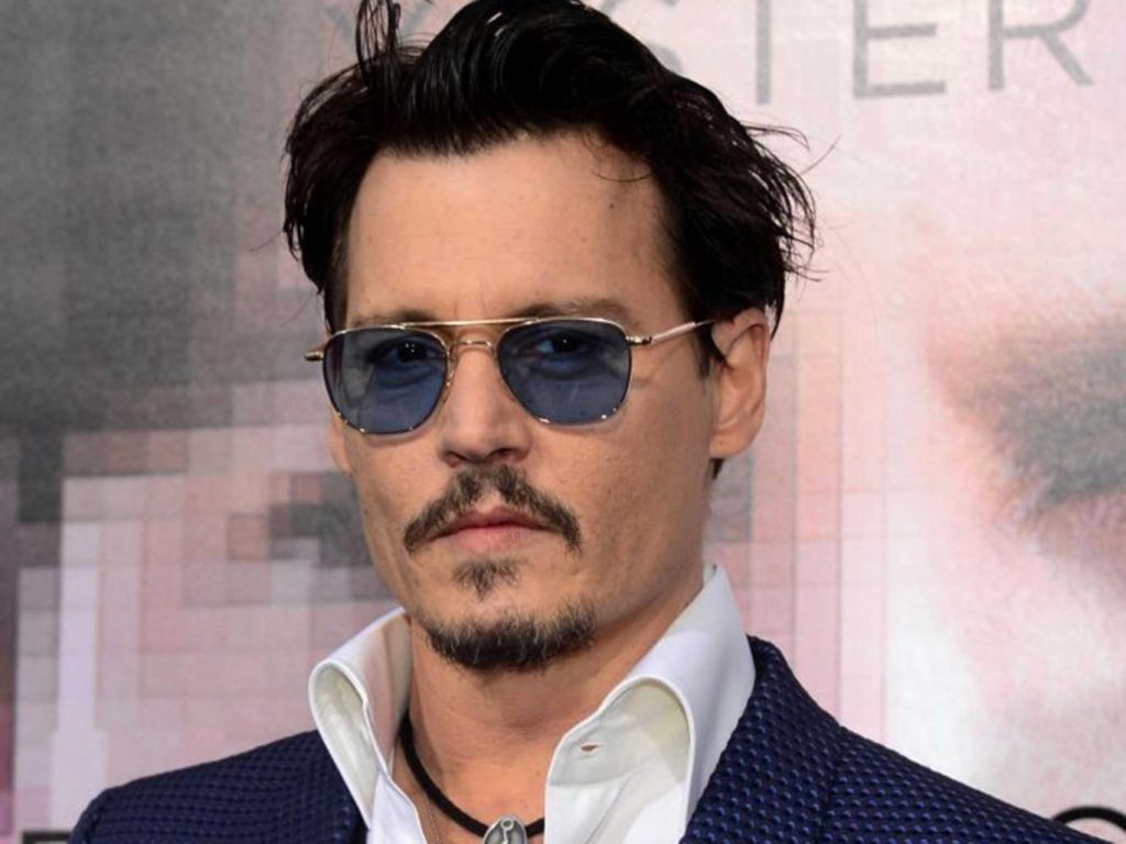 Ο Johnny Depp με γυαλιά ηλίου και μπλε σακάκι.