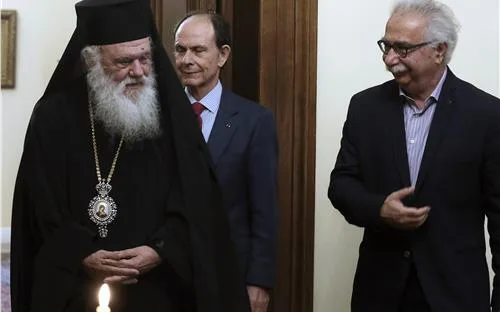 Ο Αρχιεπίσκοπος Ιερώνυμος με δύο άνδρες με κοστούμια σε εσωτερικό χώρο.